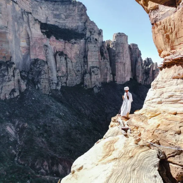 A priest on the entrance of Abuna yemata guh, a cliff faced and one of the best preserved monolithic churches.