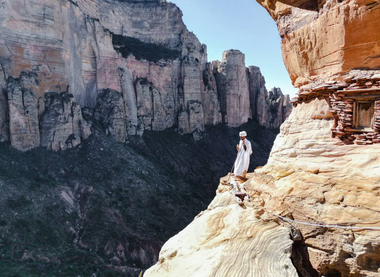A priest on the entrance of Abuna yemata guh, a cliff faced and one of the best preserved monolithic churches.